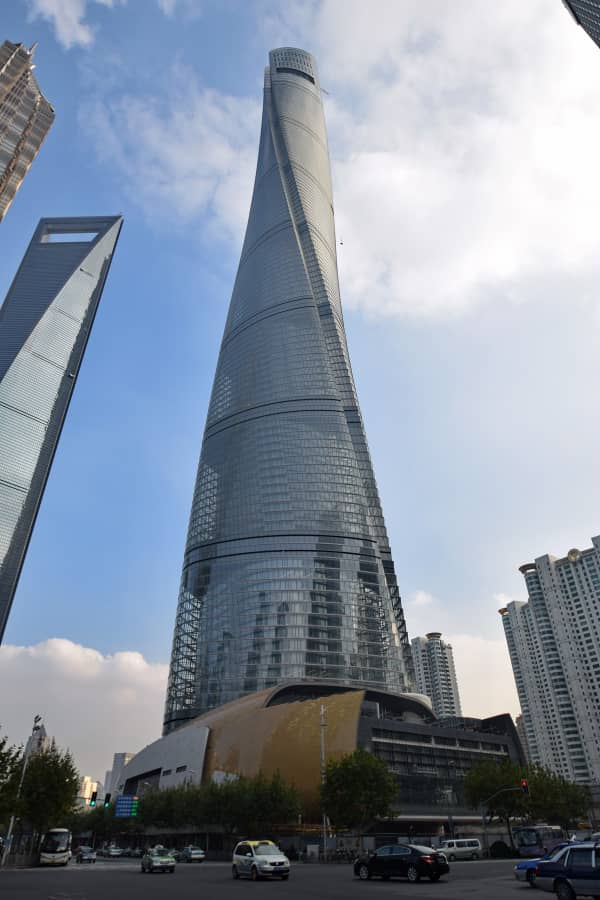 Chine : visitons la Tour de Shanghai, le troisième gratte-ciel le plus long du monde  Situé dans le quartier financier de Lujiazui, district de Pudong en plein centre de Shanghai, la Tour de Shanghai est un chef-d’œuvre architectural. Du haut de ses 632 mètres, cette édifice est le plus haut bâtiment de la Chine et se pointe à la troisième position des gratte-ciel les plus longs du monde après la Burj Khalifa à Dubaï (828 m) et la Merdeka 118 en Malaisie (678,9 m).  Au-delà de sa gigantesque forme, la Tour de Shanghai détient de loin le record du plus long observatoire du monde loin devant tous les autres gratte-ciels.    Ce bâtiment compte 127 étages sur le sol et 5 autres dans le sous-sol. Ce monument en béton se caractérise par une tour enveloppée d’une façade en verre et dont la structure forme une spirale ascendante.  Construit pendant sept ans soit de 2008 à 2015, la Tour de Shanghai a été bâtie sur base de la conception du design chinois ressemblant à un « dragon », un emblème de puissance et d’abondance ancré dans la société chinoise.  Sa conception avait aussi tenu compte des défis environnementaux auxquels fait face la ville de Shanghai, à savoir les typhons et les séismes de basse magnitude.   La Tour de Shanghai est l’un des gratte-ciels les plus écoénergétiques au monde. Ceci s’explique par	 sa façade à double peau. L’espace intermédiaire entre ses deux couches de verre, agit comme une isolation thermique, réduisant ainsi considérablement les besoins énergétiques pour le chauffage et la climatisation. Elle intègre aussi un système de récupération des eaux pluviales pour alimenter les sanitaires et pour irriguer les nombreux jardins internes, contribuant à l’efficacité environnementale de l’édifice. Il n’y a pas que des bureaux, un hôtel 5 étoiles, des salles de conférence dans ce gigantesque bâtiment. On y retrouve également des jardins intérieurs offrent des espaces verts suspendus, créant des microclimats et améliorant la qualité de l’air intérieur.  La Tour de Shanghai a d’ailleurs obtenu la certification « Leadership in Energy and Environmental Design Or », une récompense qui témoigne de son respect des standards les plus élevés en matière de construction durable. Cette certification reconnaît les efforts considérables déployés dans la conception et la construction de la tour pour minimiser son impact environnemental.   Près de seize mille (16.000) visiteurs par jour prennent d’assaut cette tour. Ce tourisme rapporte presque près de 4 milliards de Yuans par an.  Sachez que la Chine compte dix (10) bâtiments les plus longs sur les 20 que compte le monde.   Derick Katola depuis la Ville de Shanghai